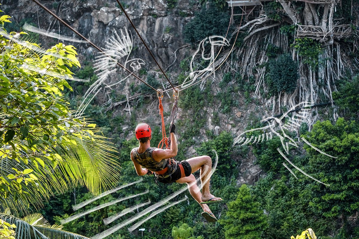 Man ziplining over mountains in Roatan.