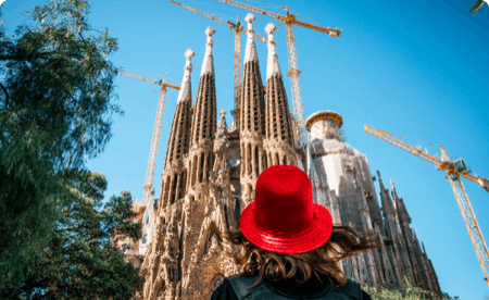 First person point of view, looking up at a cathedral behind someone in a jaunty hat.