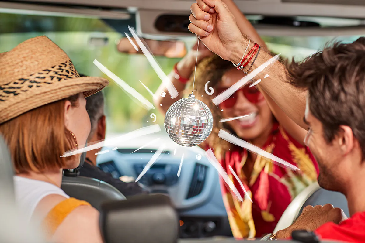 Friends in van laughing at a mini disco ball